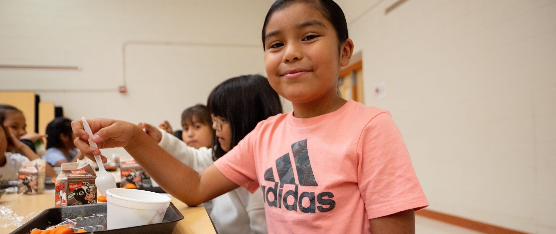 Students eating lunch together in the school cafeteria.