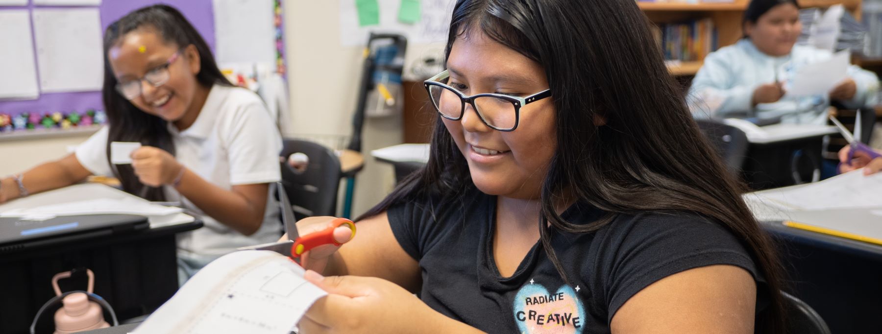 Students working on various school assignments in class.