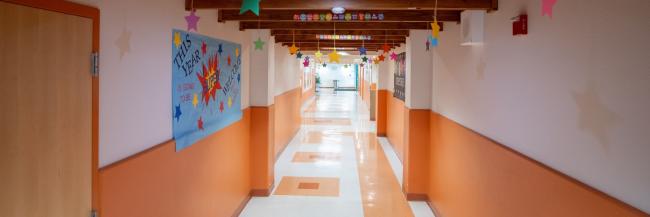 Looking down school hallway with classroom doors on each side.